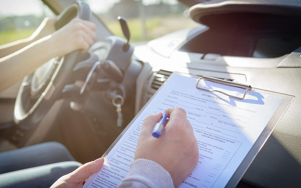 instructor writing on a form during a road test