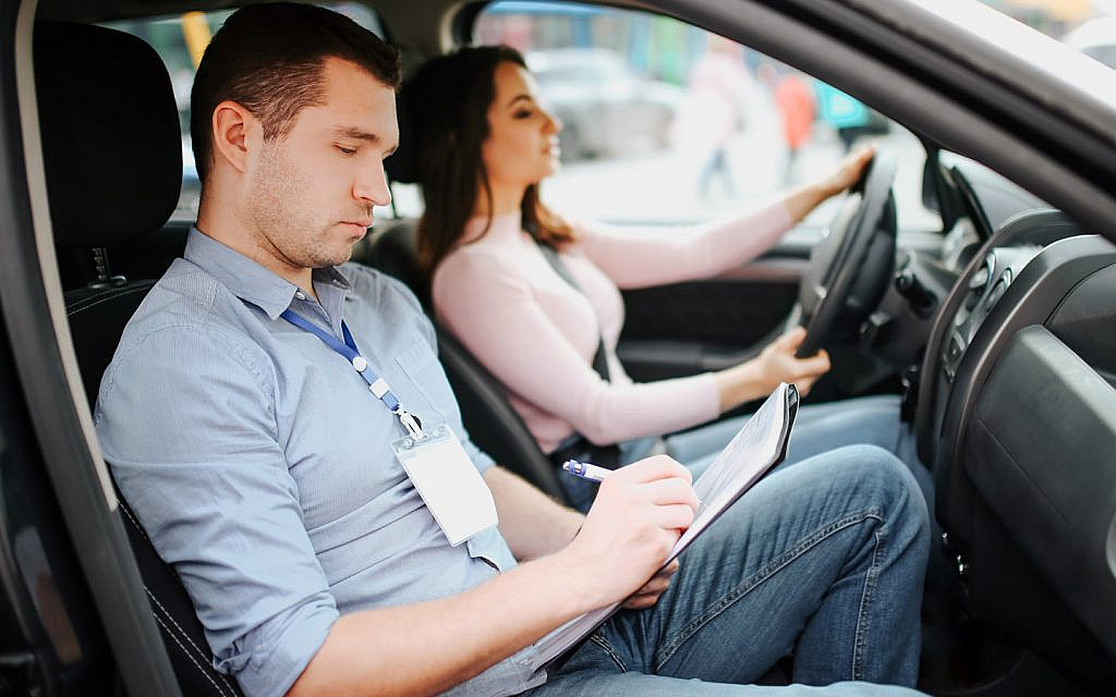 A male instructor conducting a driving licence test