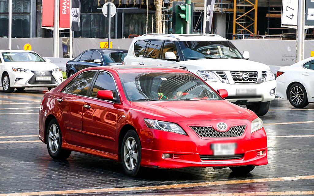 Red Toyota Camry parked on a roadside