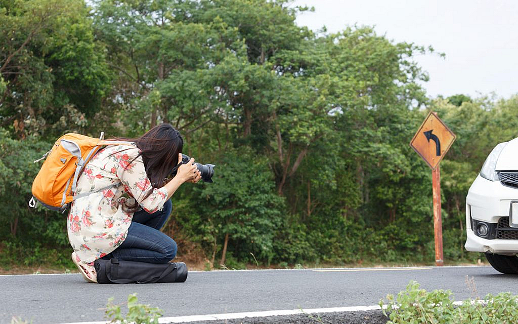 woman capturing photo of her car