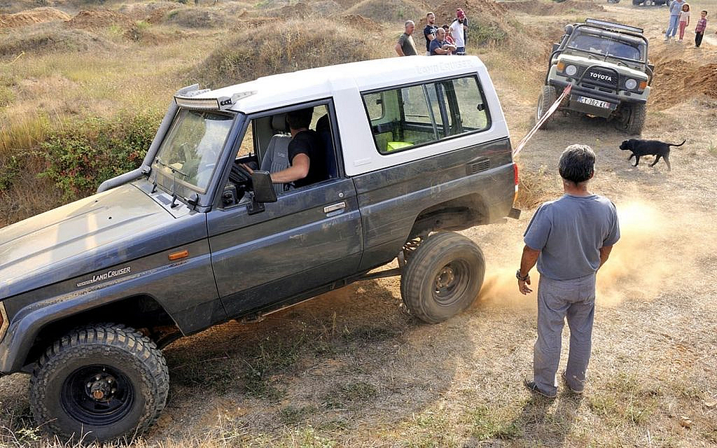 Off-road car being towed out using a recovery strap 