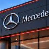 Mercedes dealership exterior with illuminated logo.