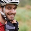 bicyclist putting on helmet