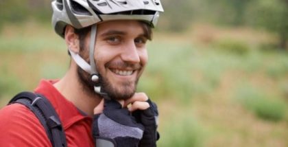 bicyclist putting on helmet
