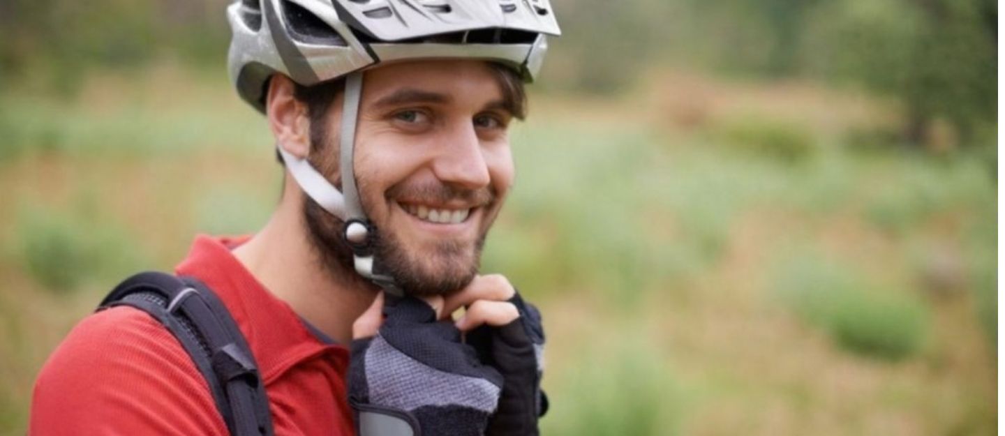 bicyclist putting on helmet