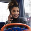 woman sitting in bus talking on phone