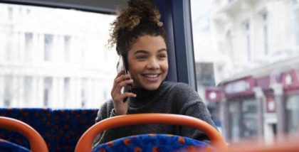 woman sitting in bus talking on phone