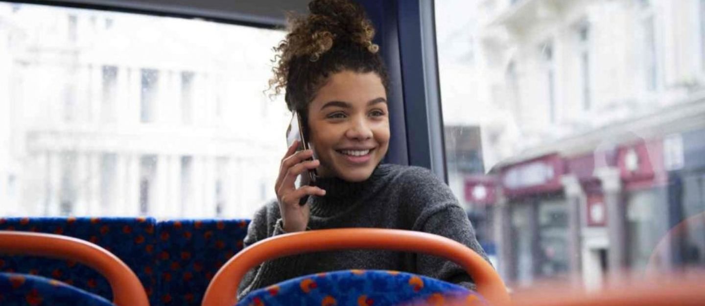 woman sitting in bus talking on phone