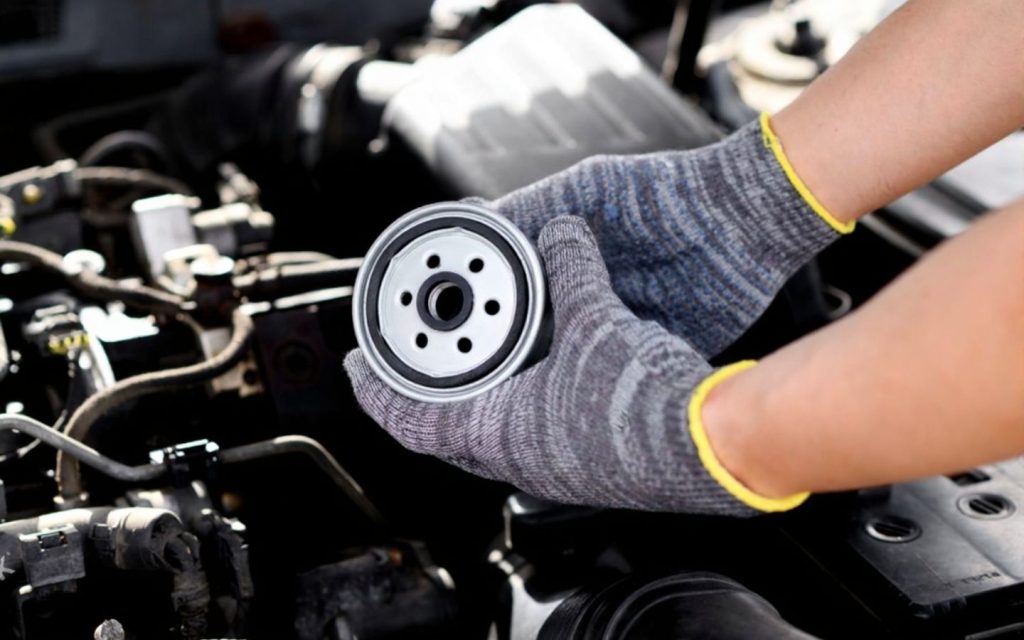 Mechanic installing fuel filter in a car