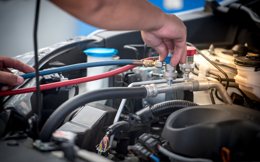 A person is fixing wires in his car before shipping
