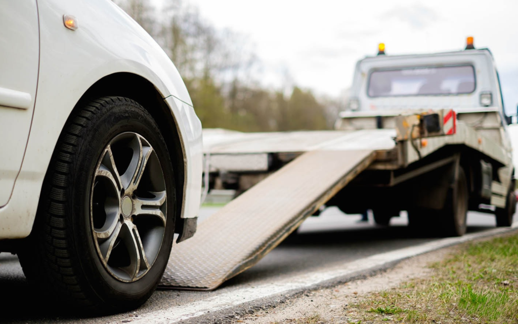 Car being loaded on a trailer using a platform