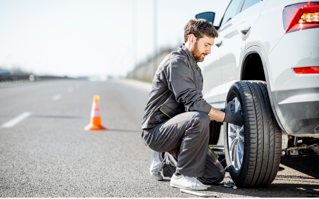 A man fixing a tyre on the roadside