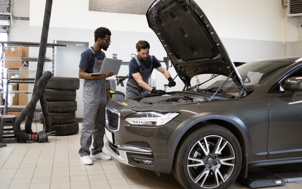 mechanics repairing the engine of a sedan