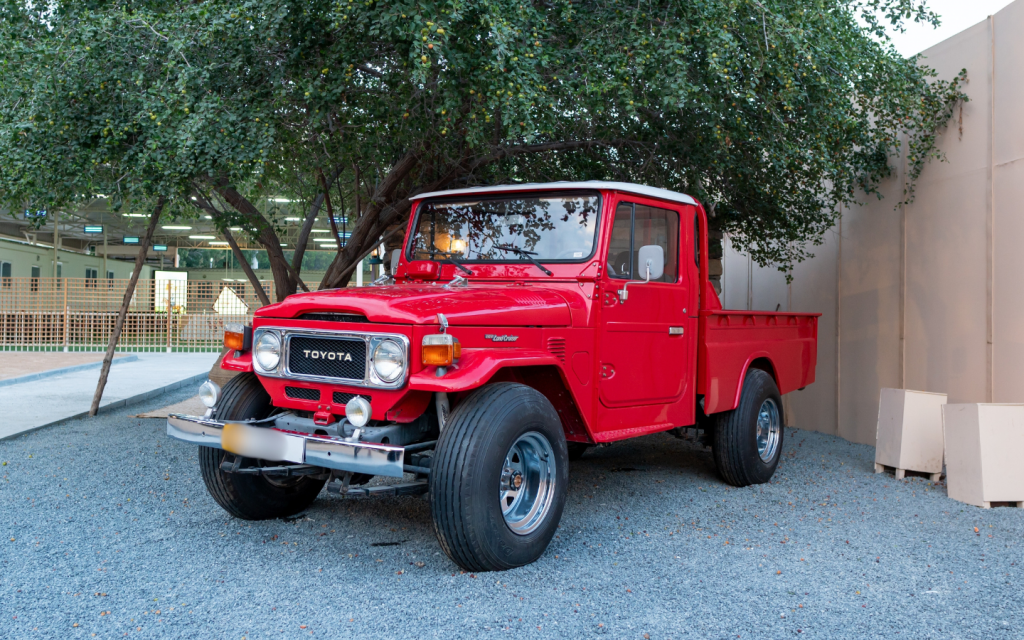 red vintage truck parked on a gravel surface