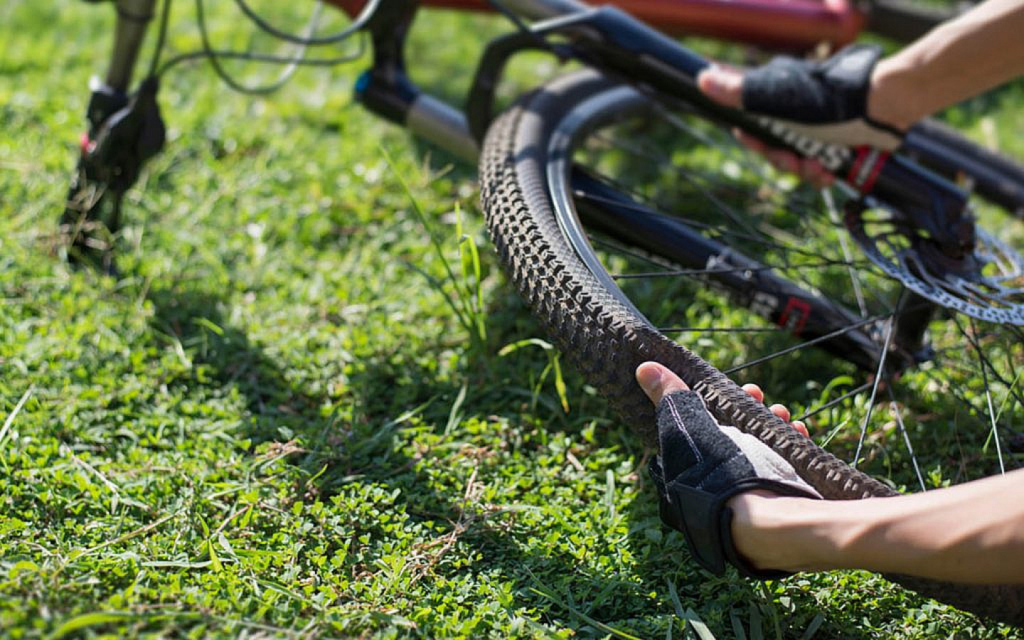 Cyclist checking a punctured tyre