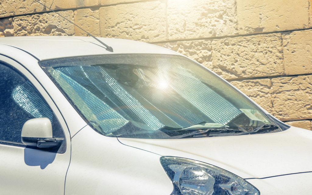 Sun shining on the windshield of a white car