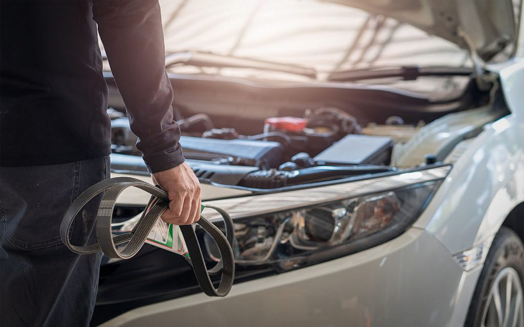 A mechanic holding car belts