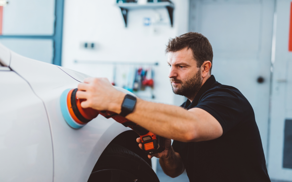 A man using suction cup on a whote car