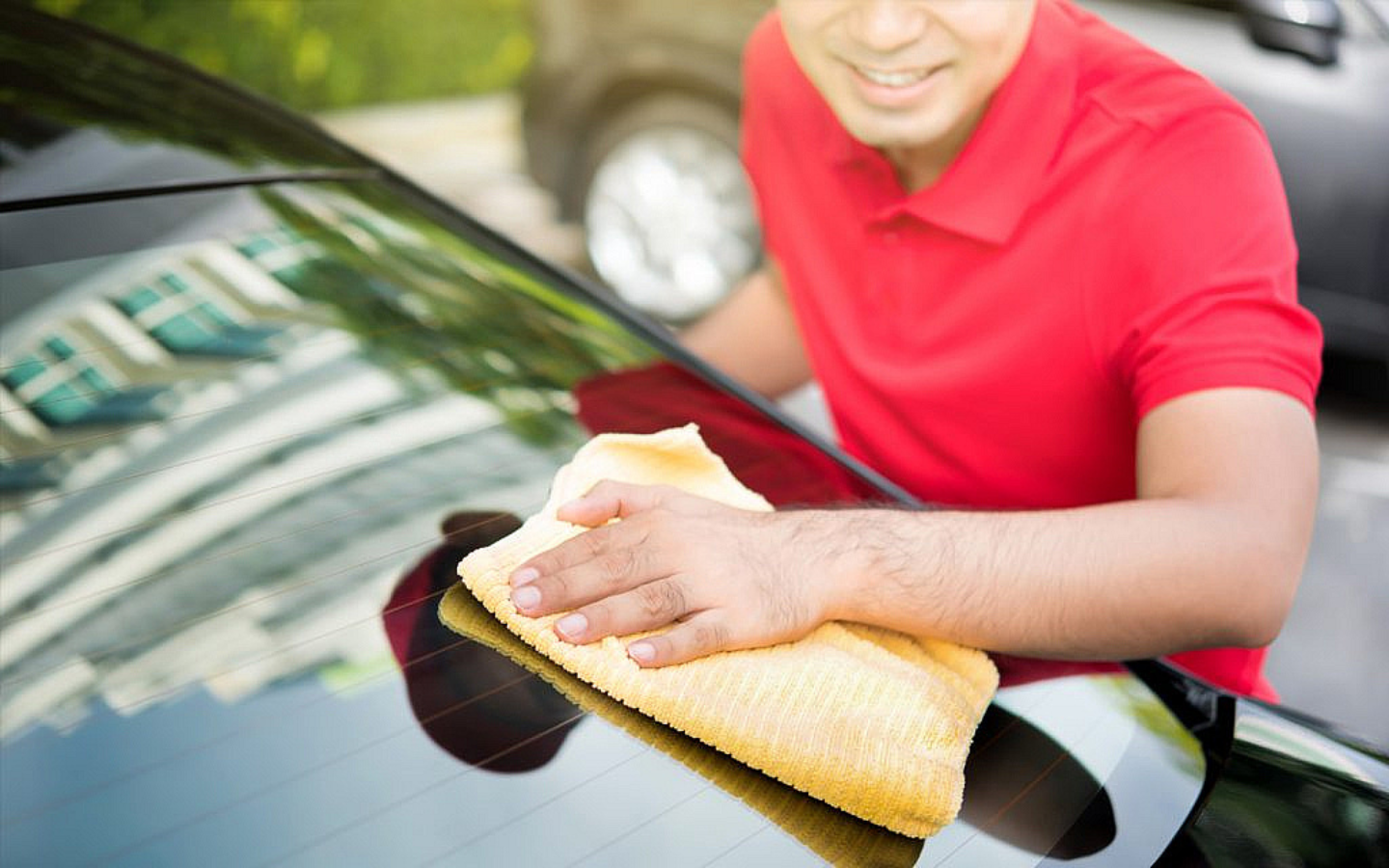 شخص يمسح زجاج السيارة الخلفي