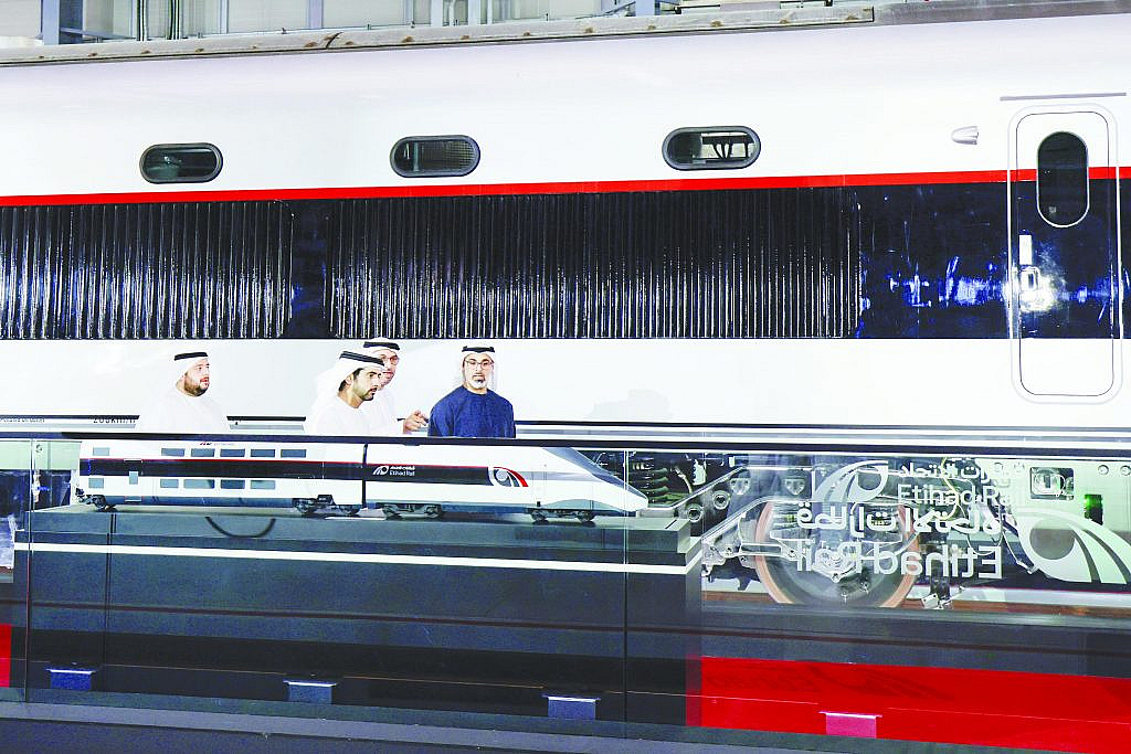 مجسم للقطار فائق السرعة بين أبوظبي ودبي وشخص يشرح عنه