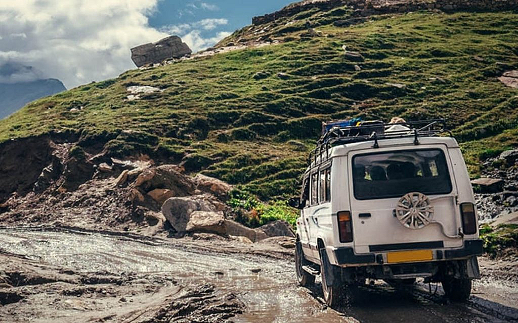 off-roading SUV crossing a rocky terrain