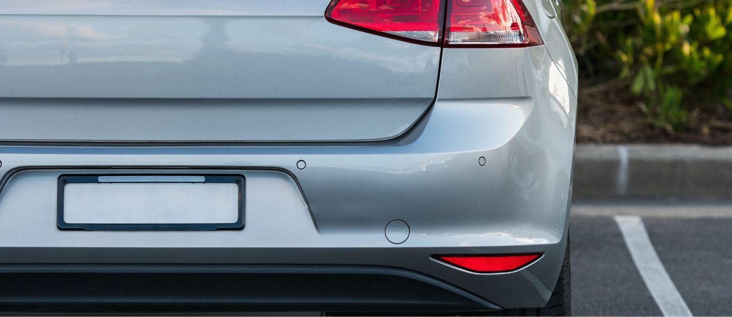 Silver Volkswagen Golf rear view with parking sensors.