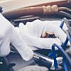 Hands with gloves repairing engine of a car