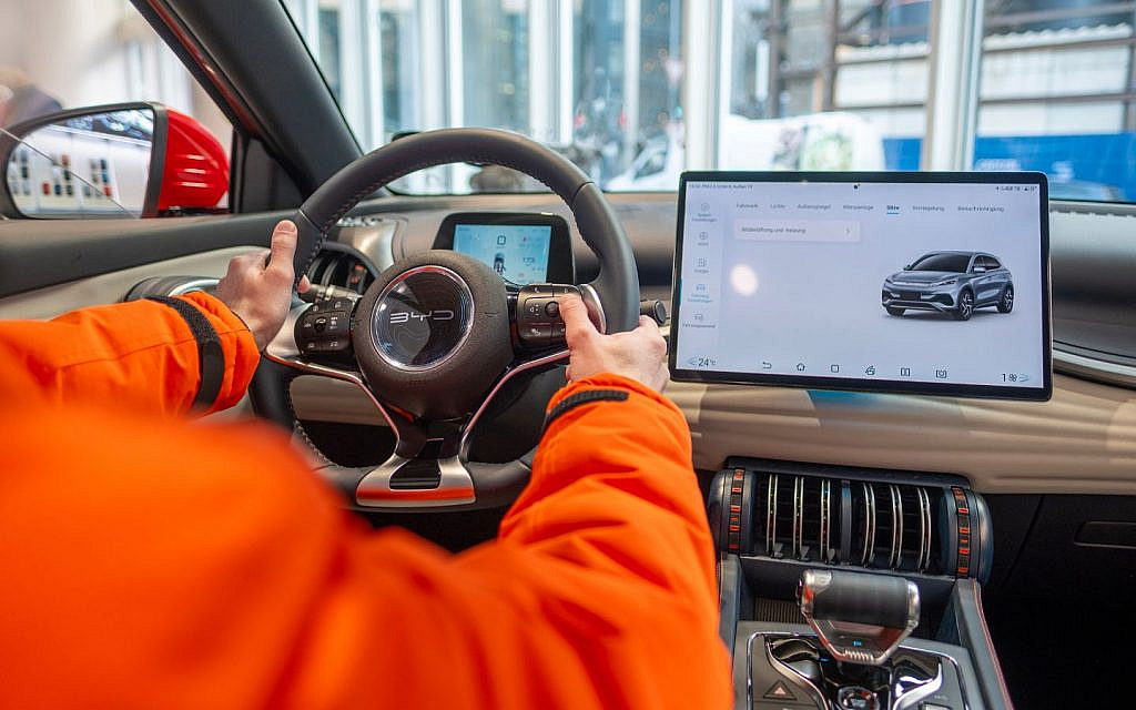 BYD Atto 3 steering wheel, hands demonstrating e-Platform 3.0 features.