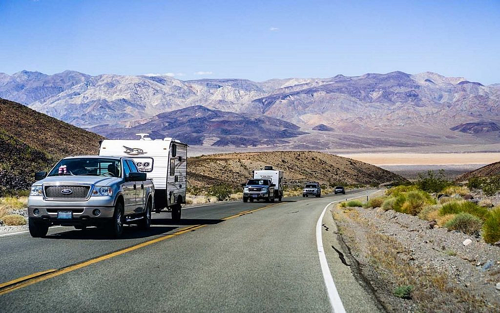Many ford trucks crossing the highway