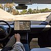 Tesla Model S interior with driver using Full Self-Driving features.