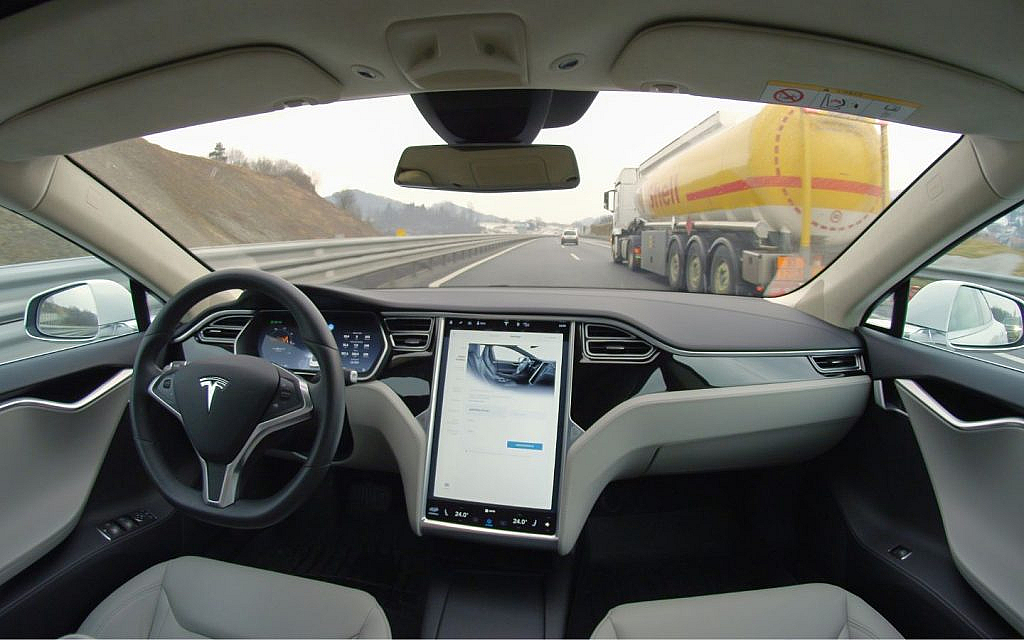 Tesla car driving autonomously on a highway.