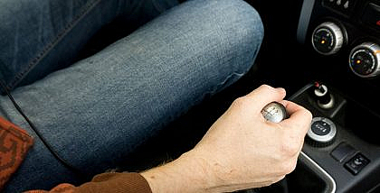Hand shifting a car's gear stick.