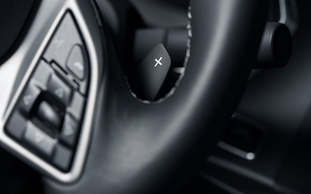 Close-up of paddle shifters mounted on a car's steering wheel.