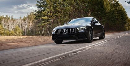 A Mercedes-Benz car is driving smoothly on a rough road.