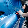 Pros and Cons of Car Wrapping - A Specialist applying thin foil to a car.