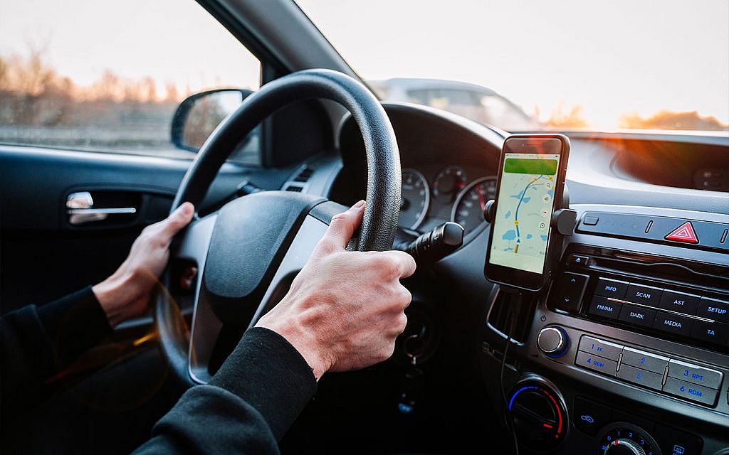 رجل يقود سيارة ويستخدم gps