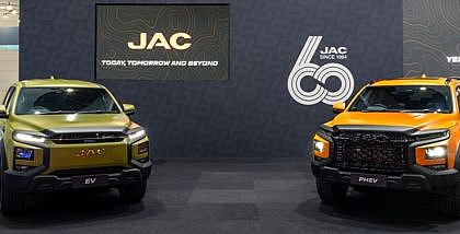 Display of JAC electric and hybrid vehicles at an auto show, highlighting innovation and facts about JAC Motors.