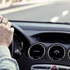 man driving on a highway with car bonnet visible