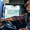 Smiling truck driver in the driver's seat, representing the journey to become a truck driver in Dubai.