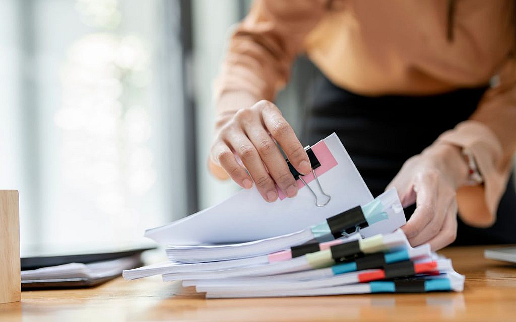 Hands sorting documents and files, representing the paperwork required for a truck driving licence in Dubai.