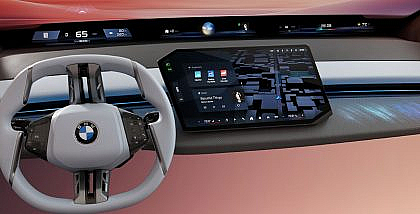 Interior view of a BMW featuring the wide BMW Panoramic iDrive screen displaying navigation, media, and vehicle information.
