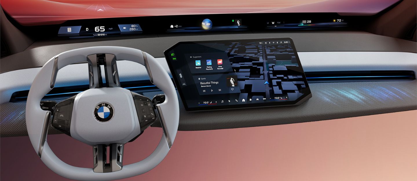 Interior view of a BMW featuring the wide BMW Panoramic iDrive screen displaying navigation, media, and vehicle information.