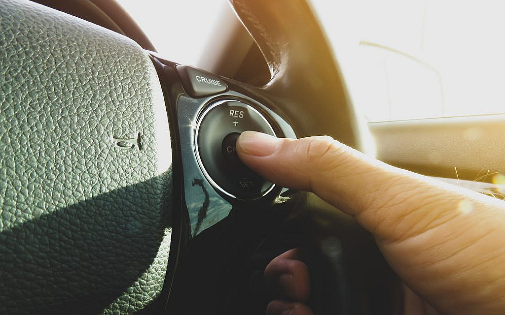 شخص يضغط زر تشغيل السيارة