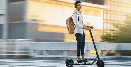 a boy riding an electric scooter in an urban area, reflecting the safe commuting goals of the RTA Personal Mobility Monitoring Unit.