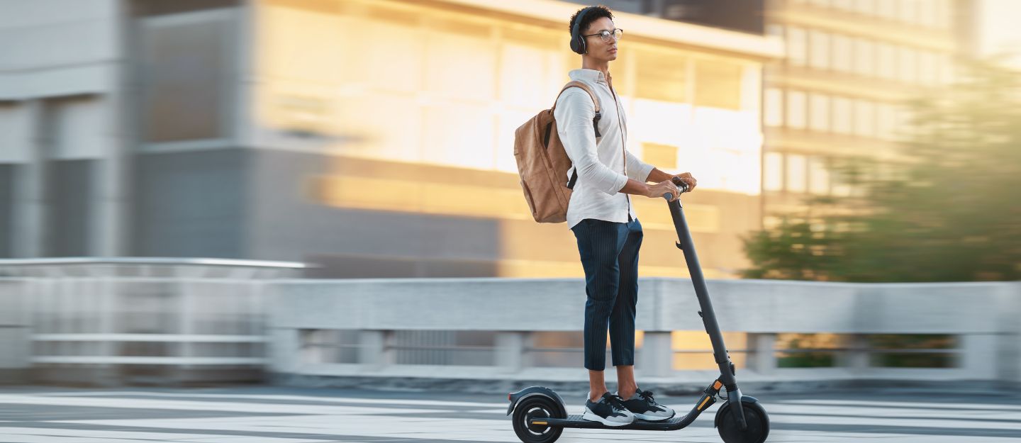 a boy riding an electric scooter in an urban area, reflecting the safe commuting goals of the RTA Personal Mobility Monitoring Unit.