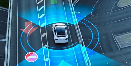 Aerial view of an autonomous car on a smart road with digital overlays, representing ISA and ACC in modern cars for enhanced safety and traffic control.
