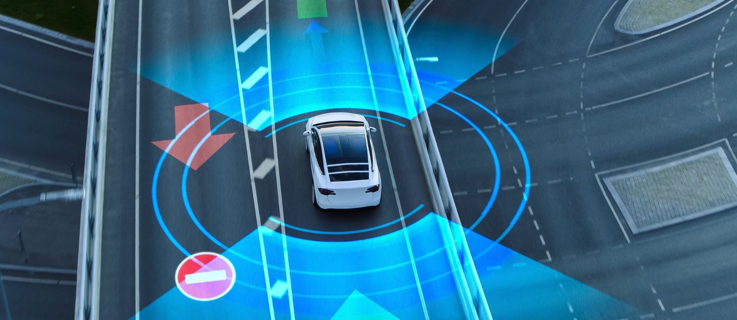 Aerial view of an autonomous car on a smart road with digital overlays, representing ISA and ACC in modern cars for enhanced safety and traffic control.