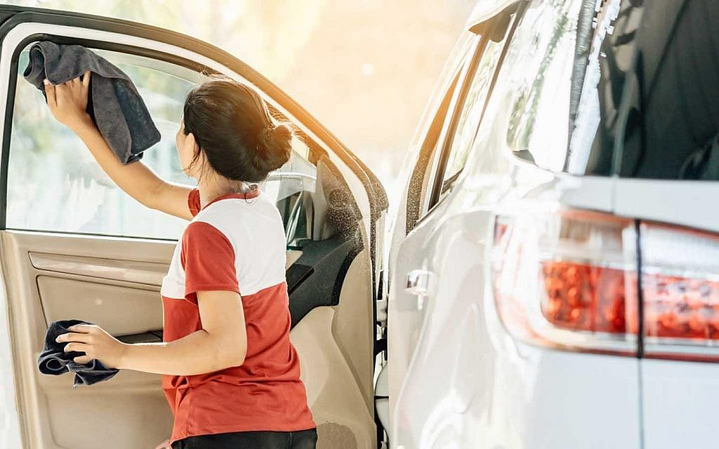 فتاة تنظف زجاج السيارة