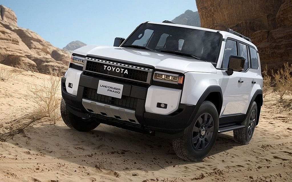 White Toyota Land Cruiser Prado off-roading on a hilly terrain