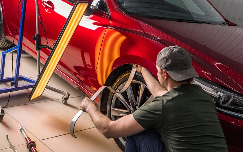 A mechanic doing paintless dent removal